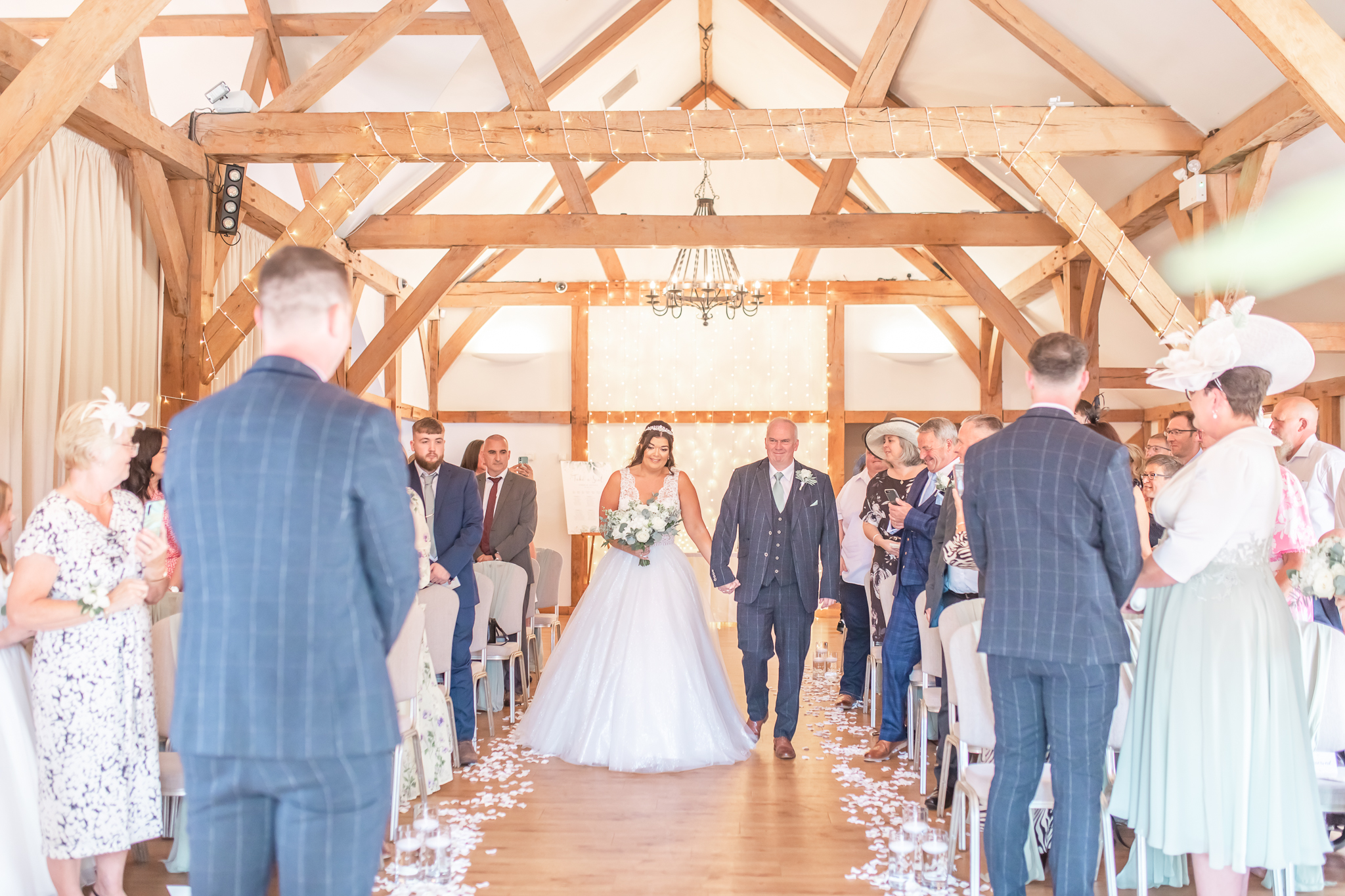 Aimee walking down the aisle at rustic wedding venue Sandhole Oak Wedding Barn, captured by Cheshire wedding photographer, Sophie Siddons