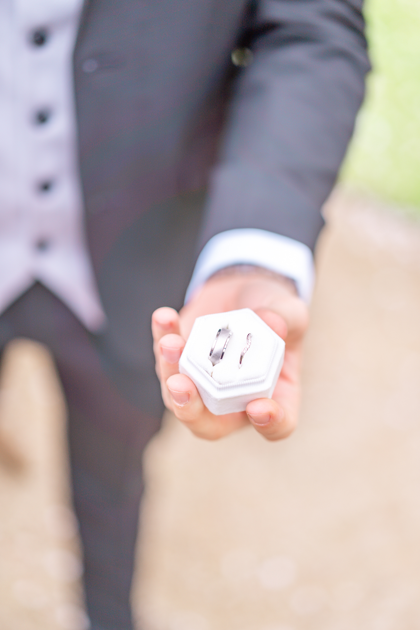 Close up of two wedding rings being held by the groom