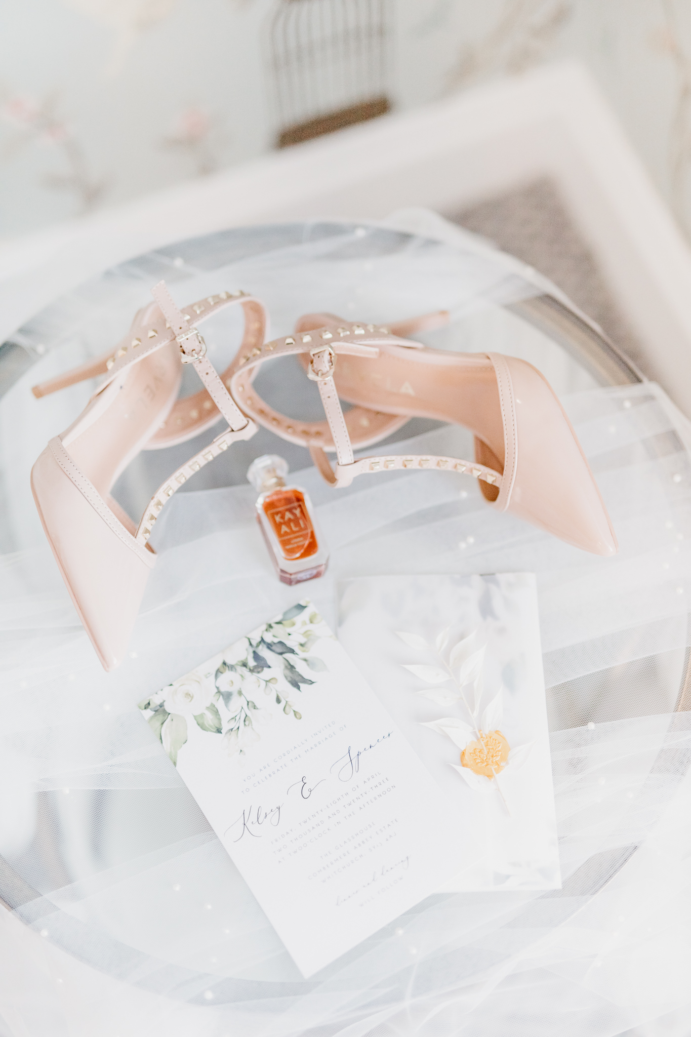 Flat lay of brides shoes, perfume and wedding invitation at Cheshire wedding venue, Combermere Abbey