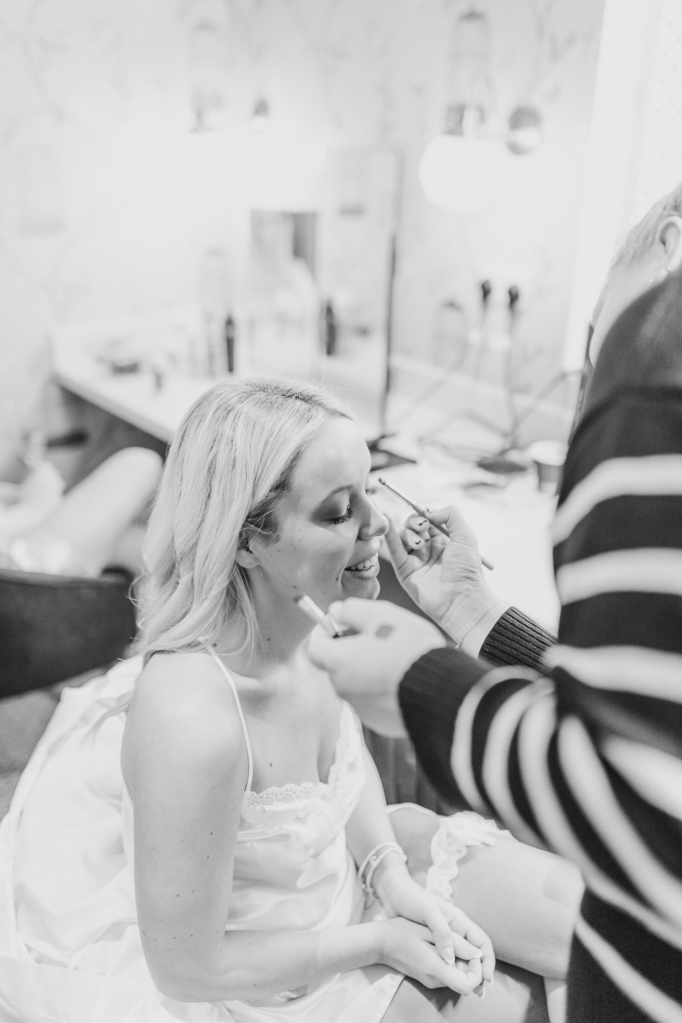 Bride, Kelsey having her make up done before her wedding at Combermere Abbey North West wedding venue