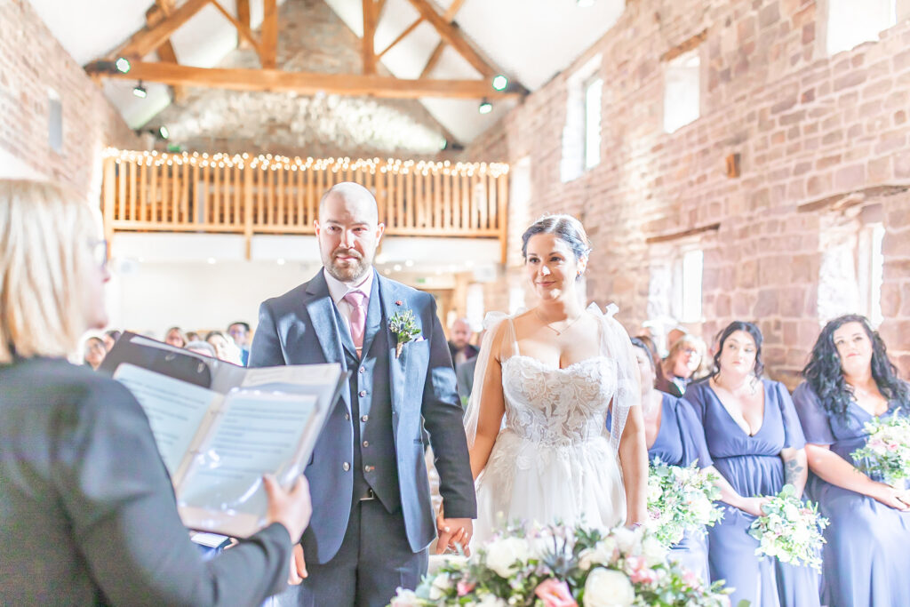 Abby and Jamie holding hands during their wedding ceremony at their wedding in Staffordshire at The Ashes Barns
