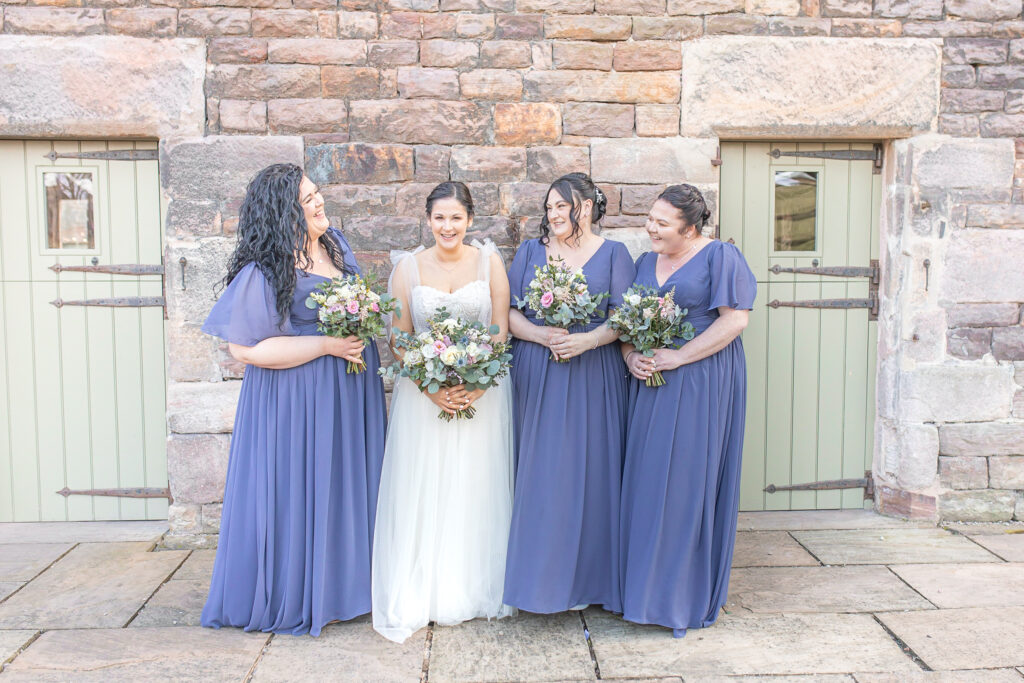 Abby and three bridesmaids stood outside The Ashes Wedding Barns in Staffordshire