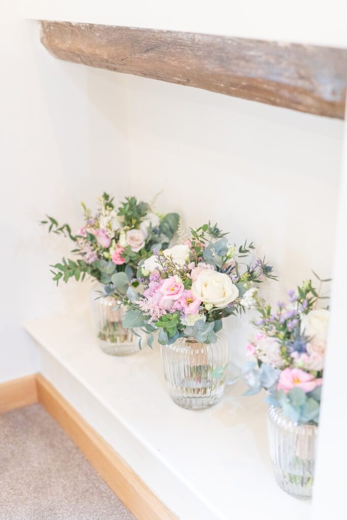 Bridal flowers in glass jars at The Ashes Barns Wedding Venue in Staffordshire