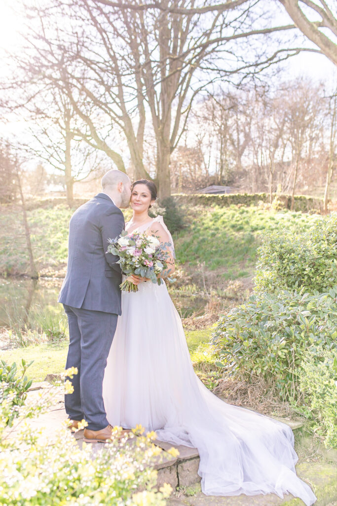Abby and Jamie sharing a moment by the water at The Ashes Wedding venue in Staffordshire, taken by North West wedding photographer, Sophie Siddons