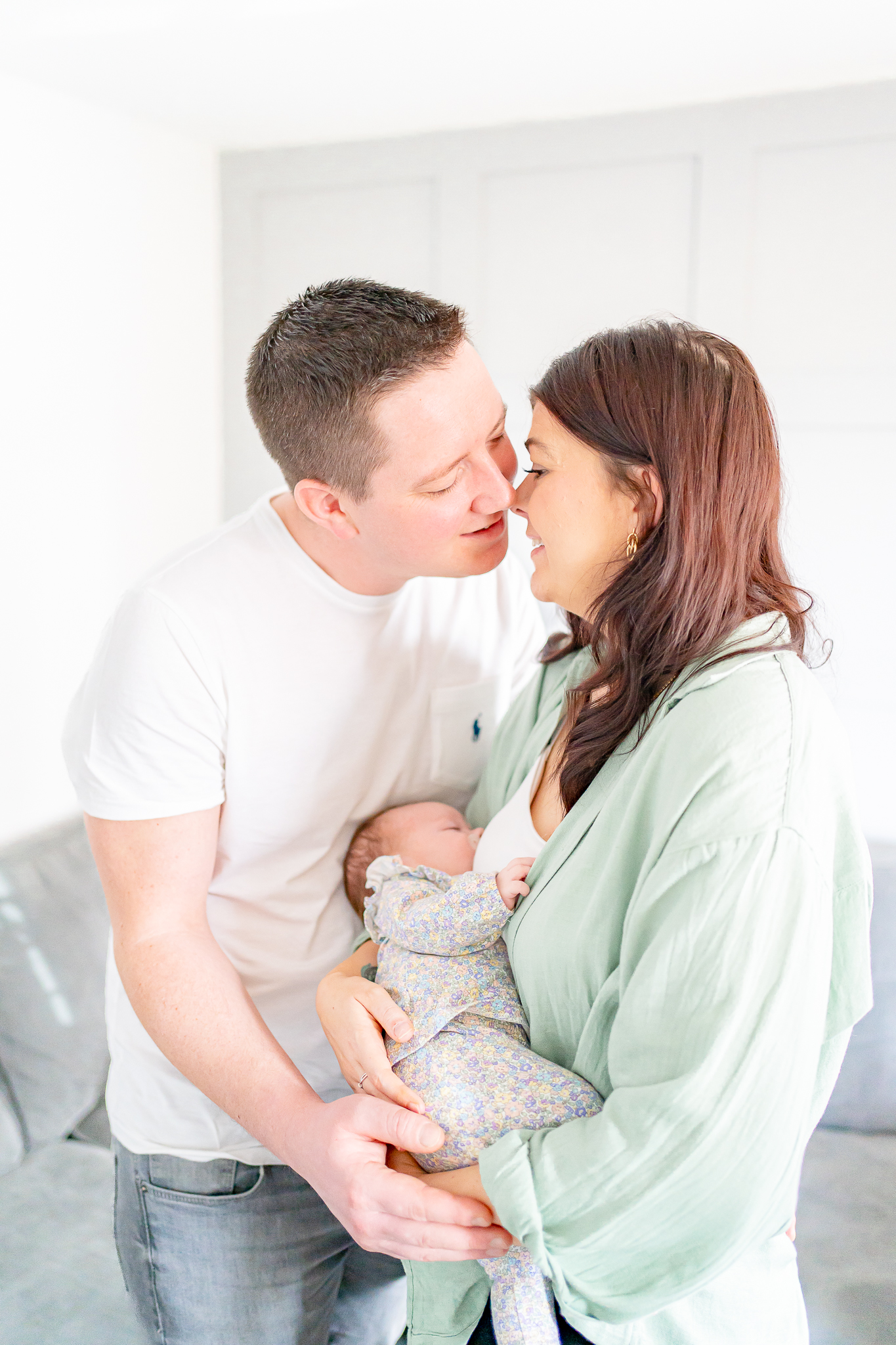 Mum and dad sharing a kiss while holding their new born