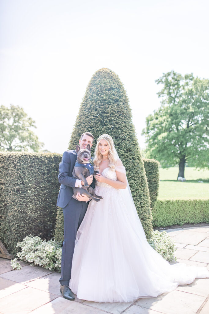 Bride and Groom at their wedding holding their dog