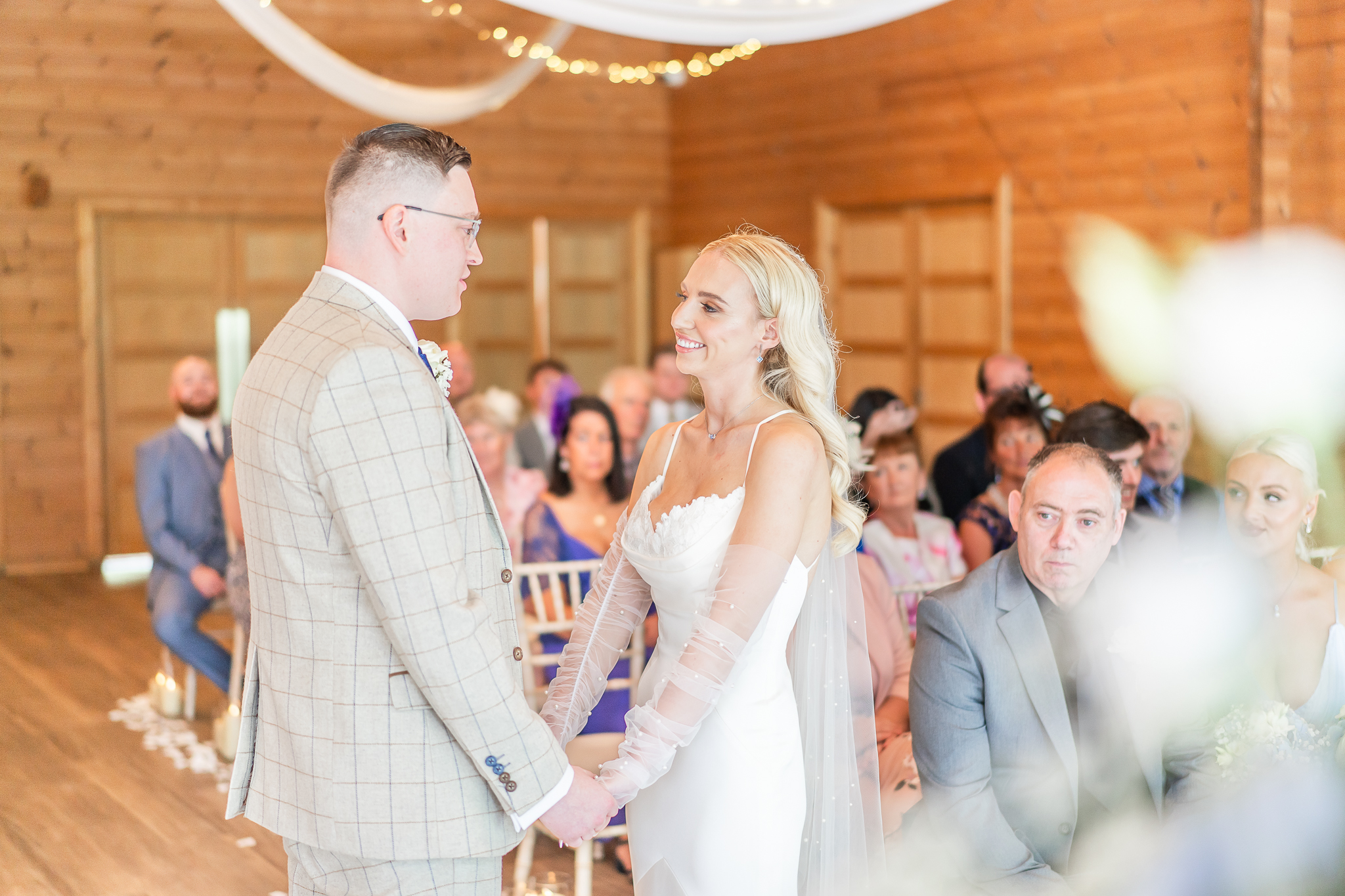 Bride and groom holding hands during the ceremony at Styal Lodge in Cheshire