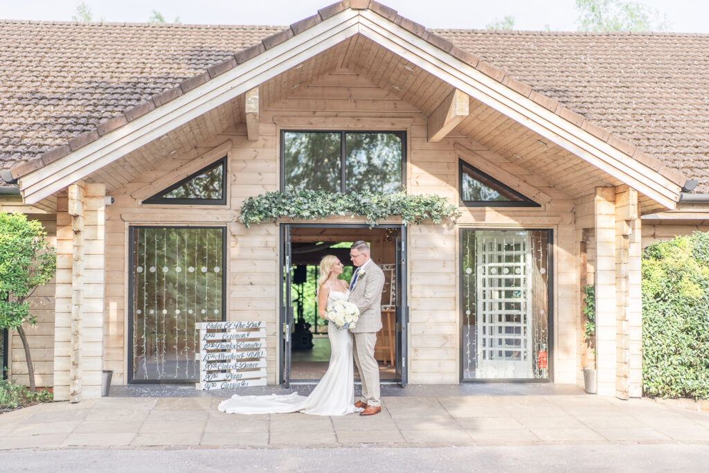 Bride and groom facing each other outside Styal Lodge wedding venue