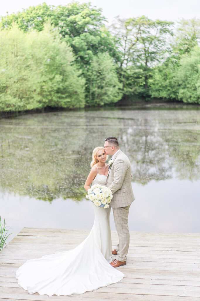 Bride and groom in front of the lake at Styal Lodge in Cheshire