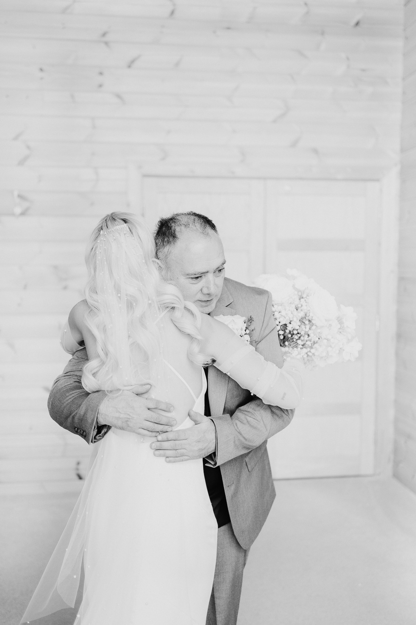 Father of the bride and bride hugging